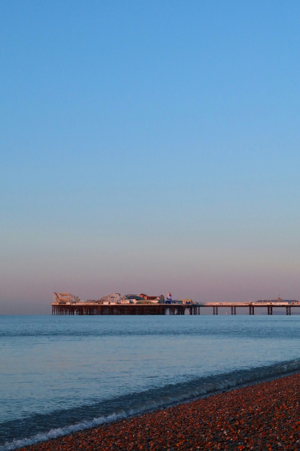 a beach with a pier in the distance