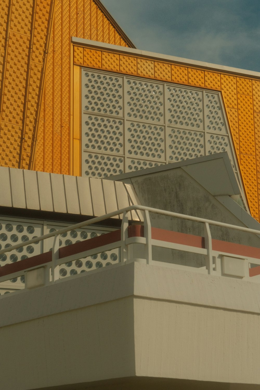 un bâtiment avec un toit en métal et une balustrade blanche