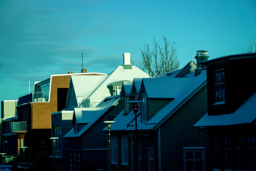 a row of houses covered in snow under a blue sky