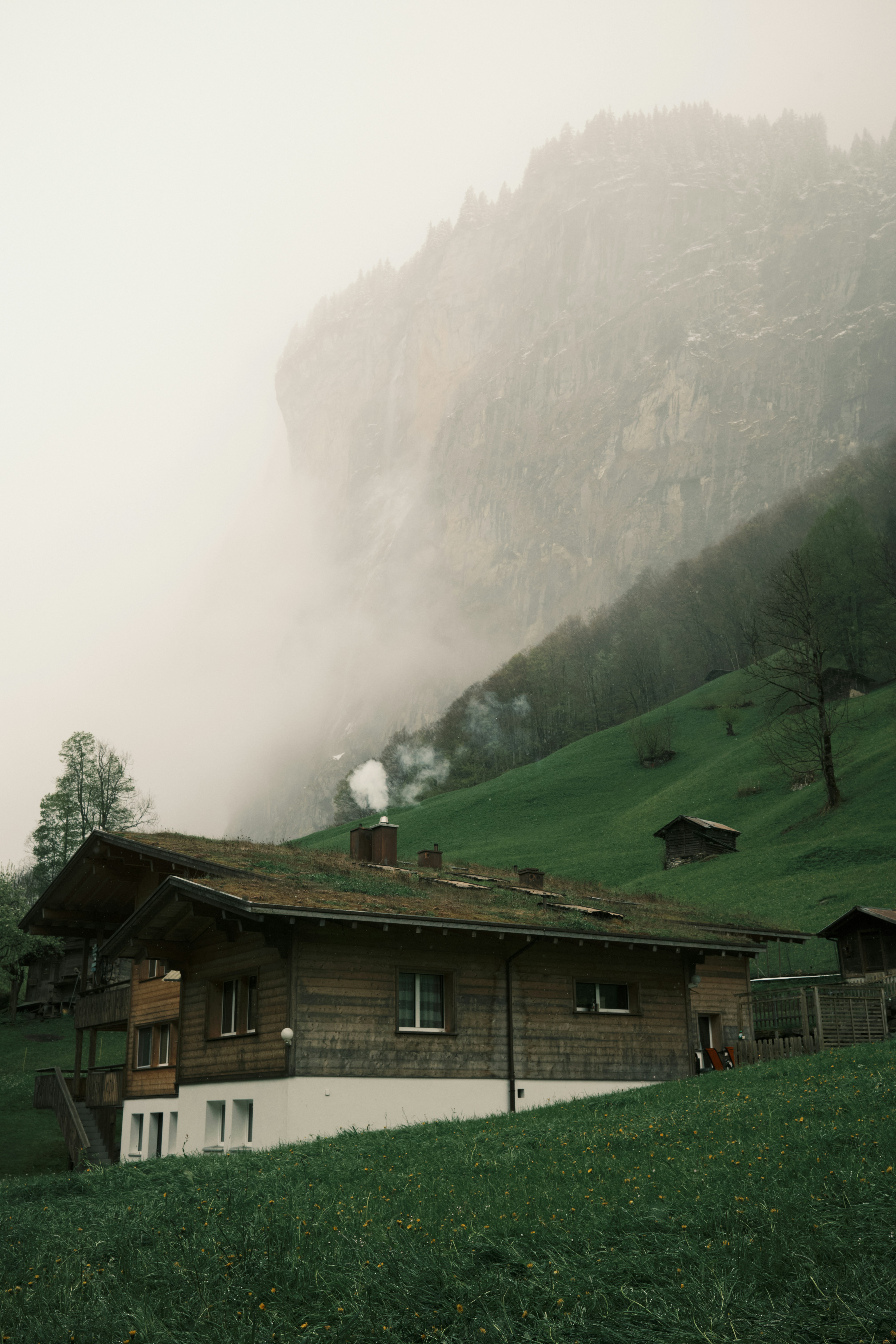 Ein Haus mit grünem Dach und einem Berg im Hintergrund