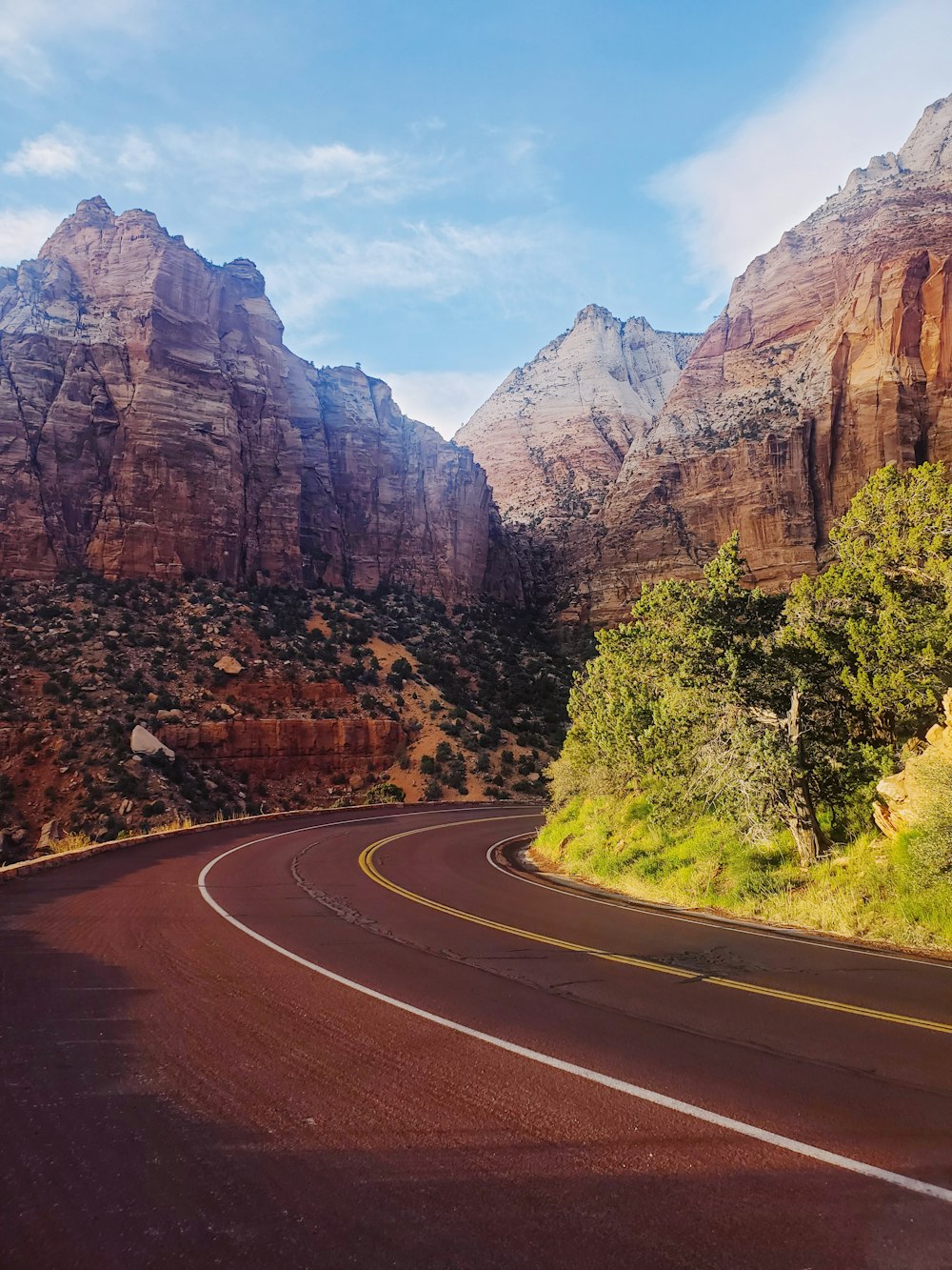 a curved road with mountains in the background