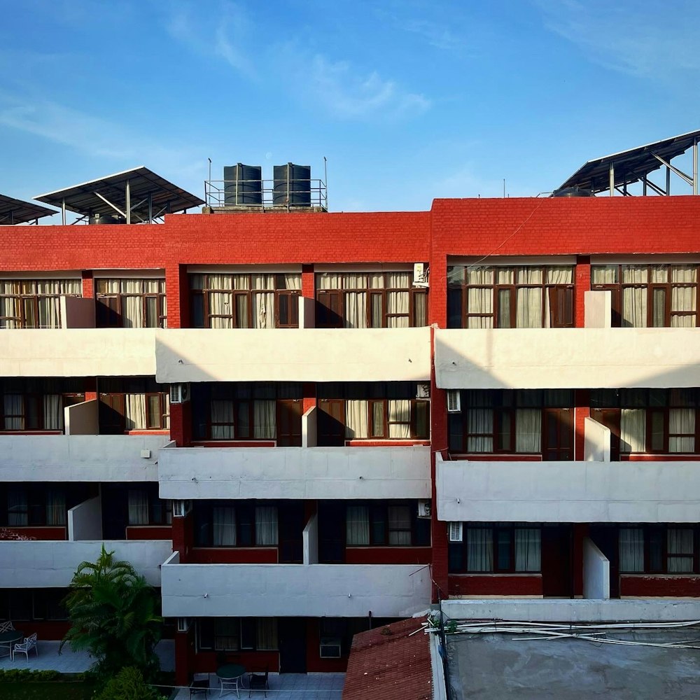 a red and white building with windows and balconies