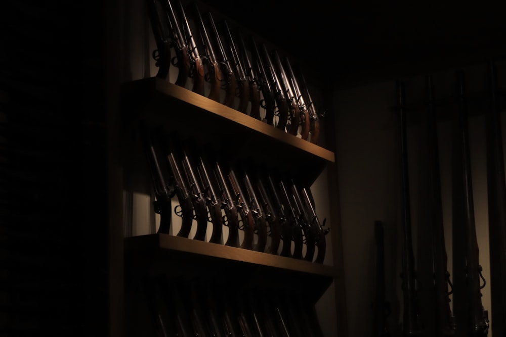 a shelf filled with lots of guns in a dark room