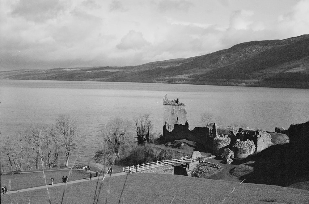 a black and white photo of a castle by a lake