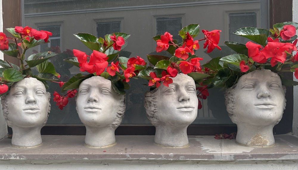 a group of three heads with flowers in them