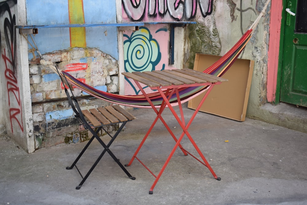 a chair and a table in front of a wall with graffiti