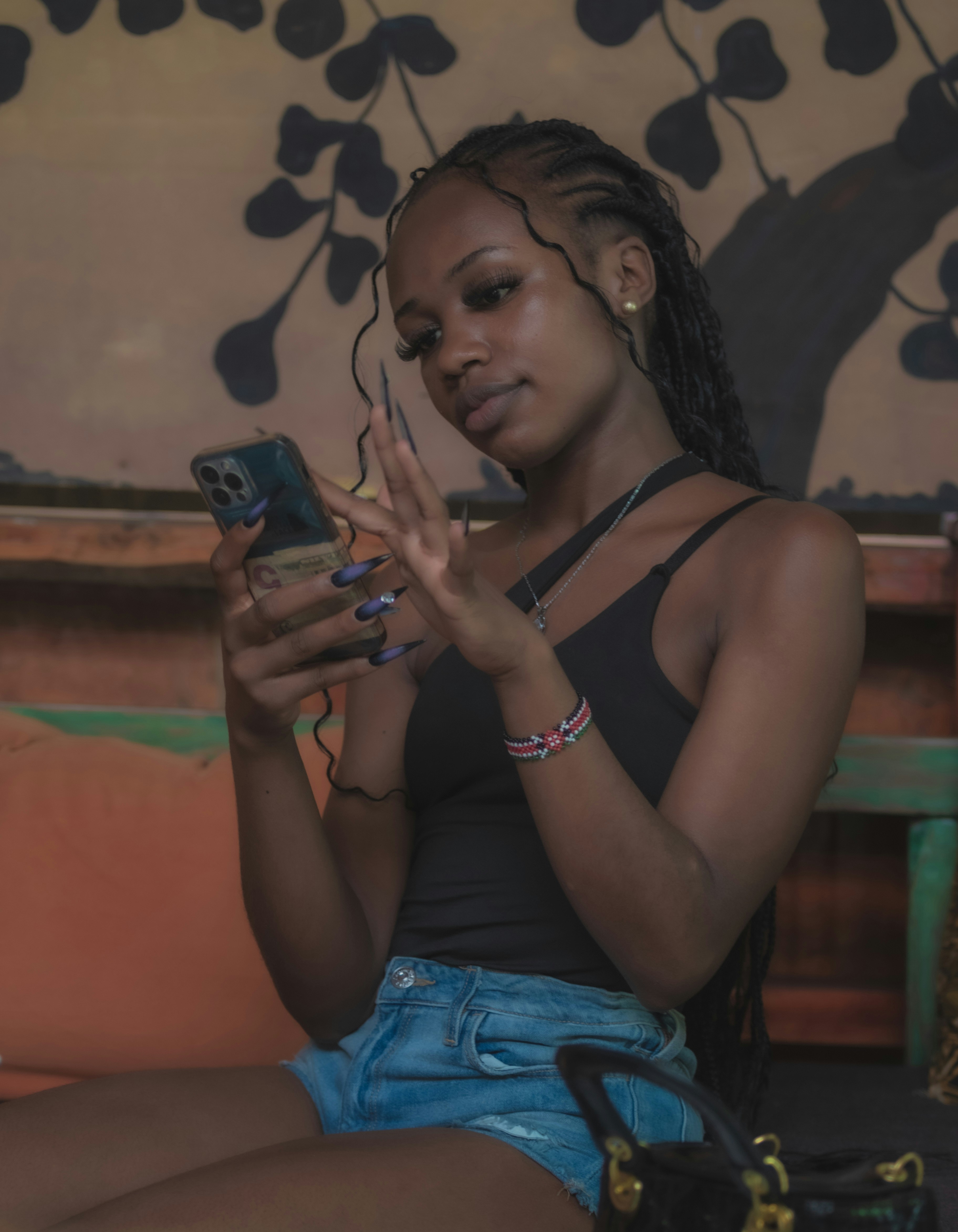 a woman sitting on a couch looking at her cell phone