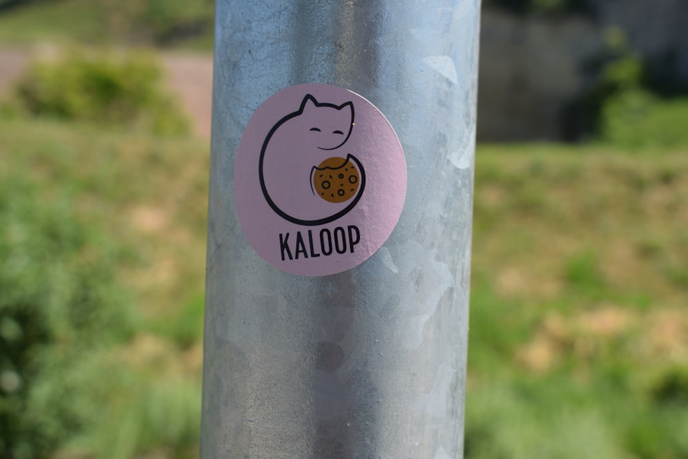 a sticker on a pole with a picture of a cat eating a cookie