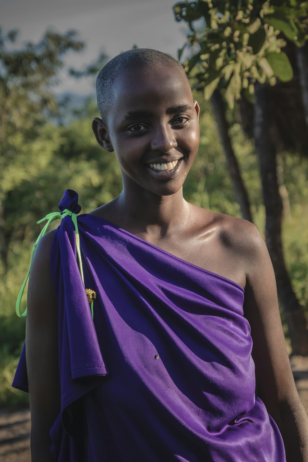 a woman in a purple dress smiles for the camera