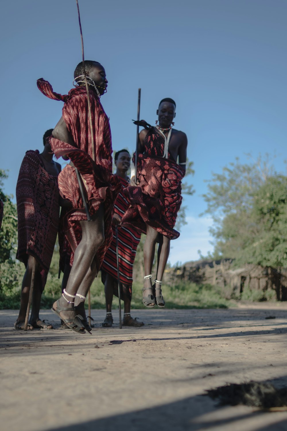 a group of people standing on top of a dirt road