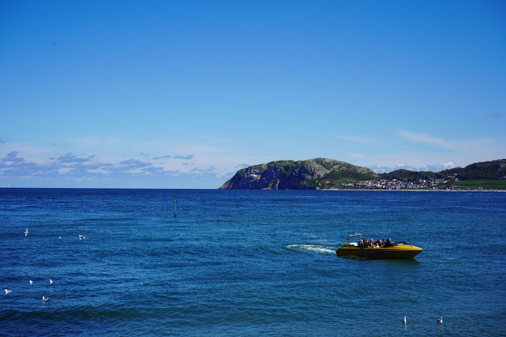 a small yellow boat in the middle of the ocean