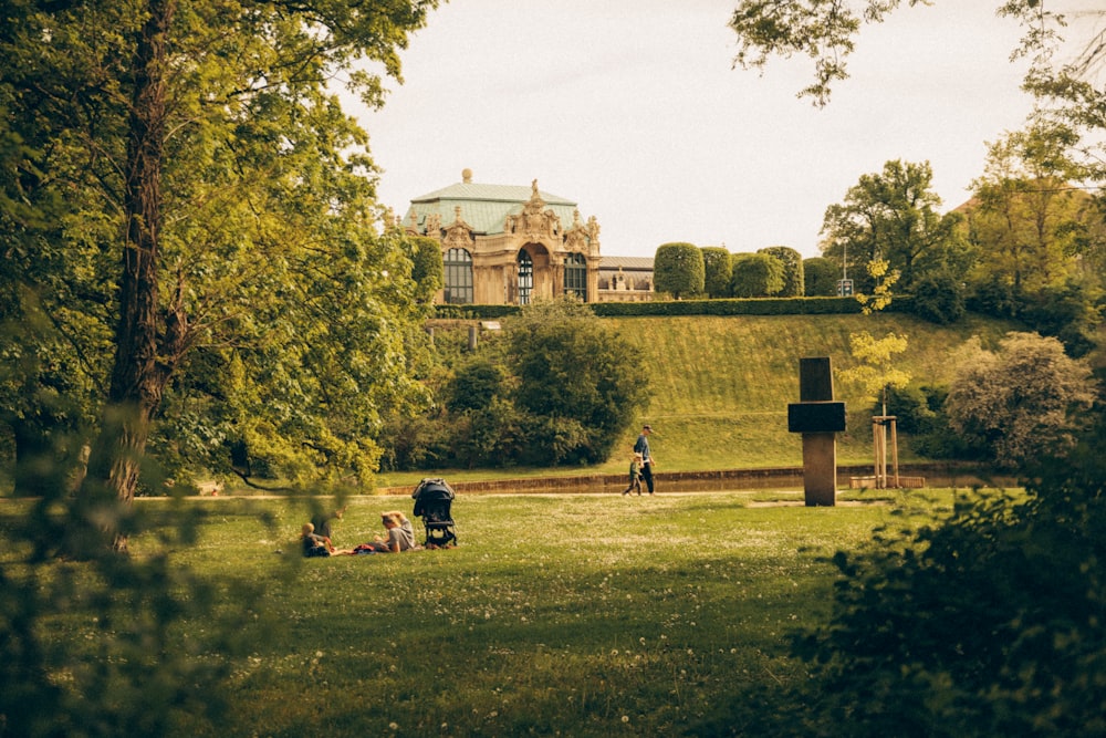 a group of people sitting on top of a lush green field