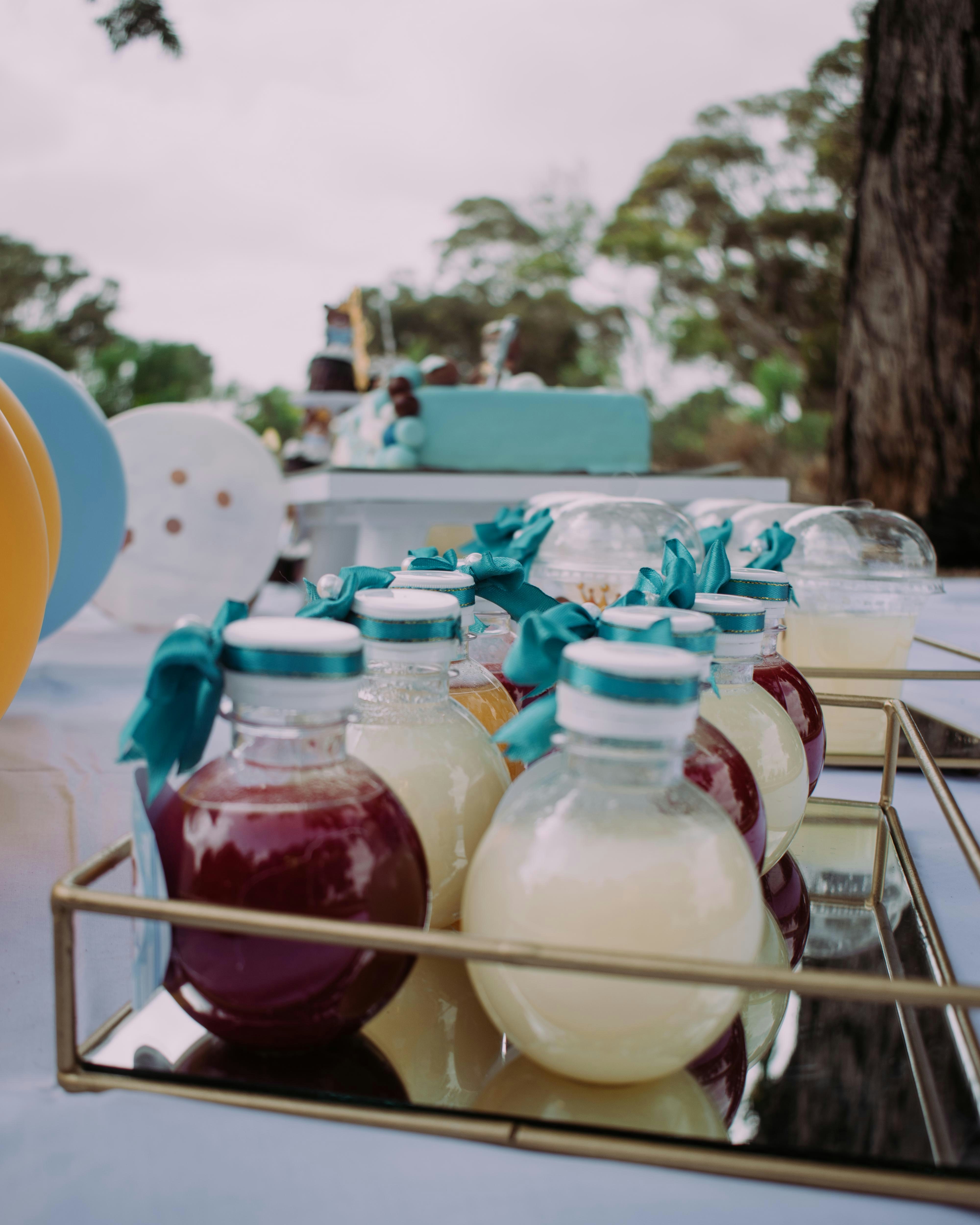 Personalised water bottle labels on chilled bottles at a summer birthday party in bright light