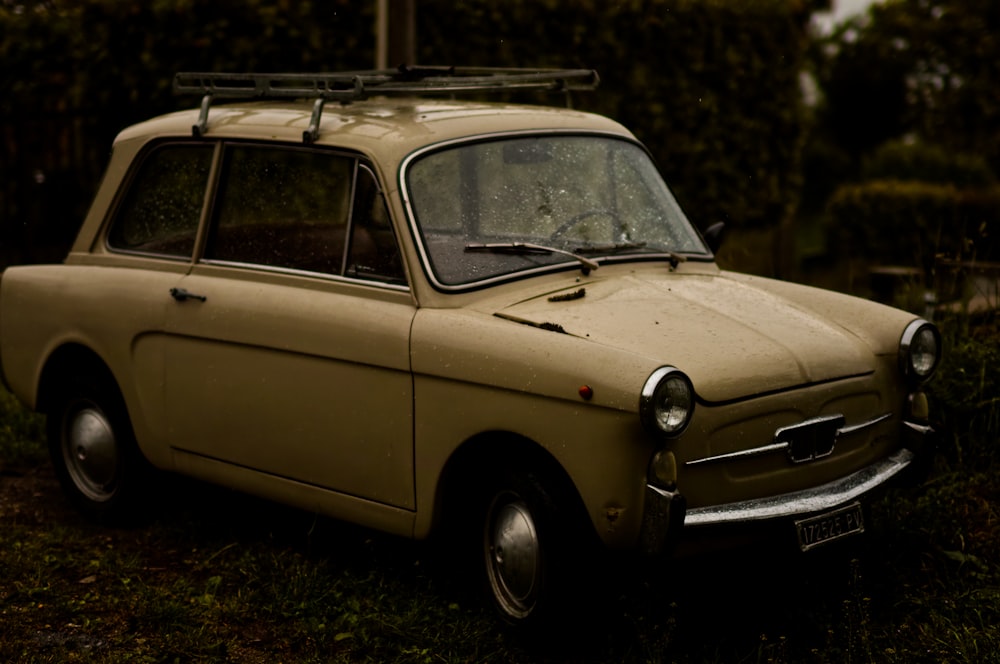 an old car is parked in the grass