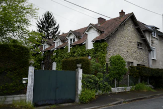 a house covered in ivy next to a road