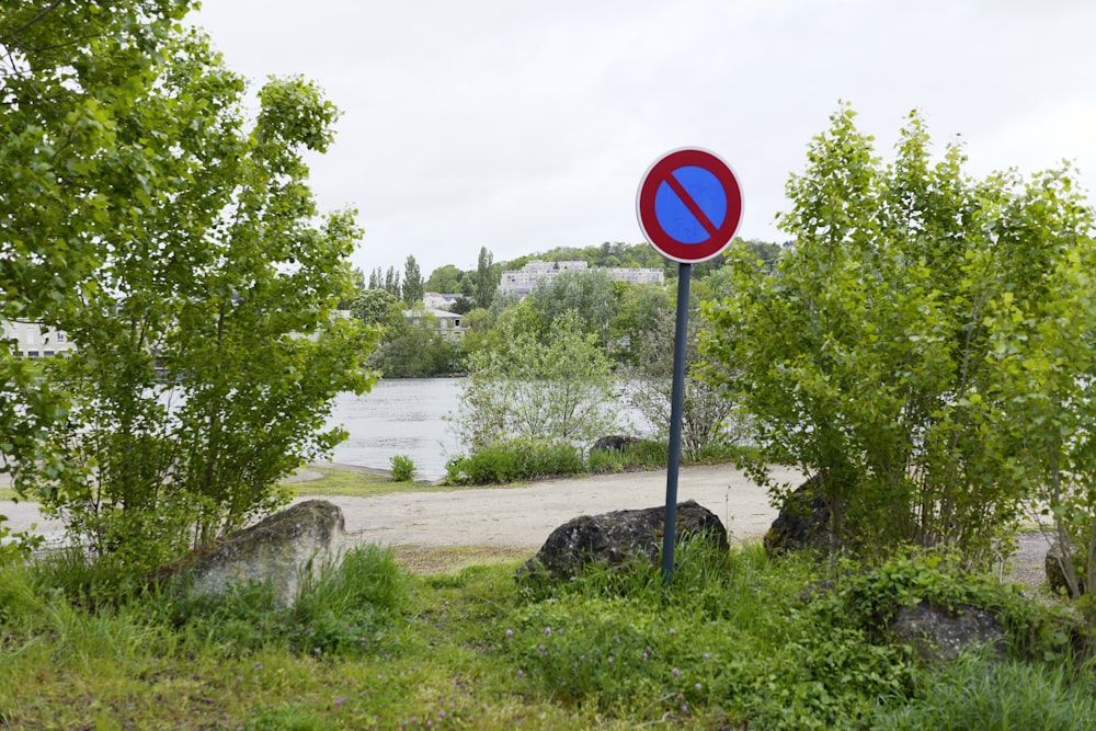 un panneau de rue rouge et bleu posé sur le bord d’une route