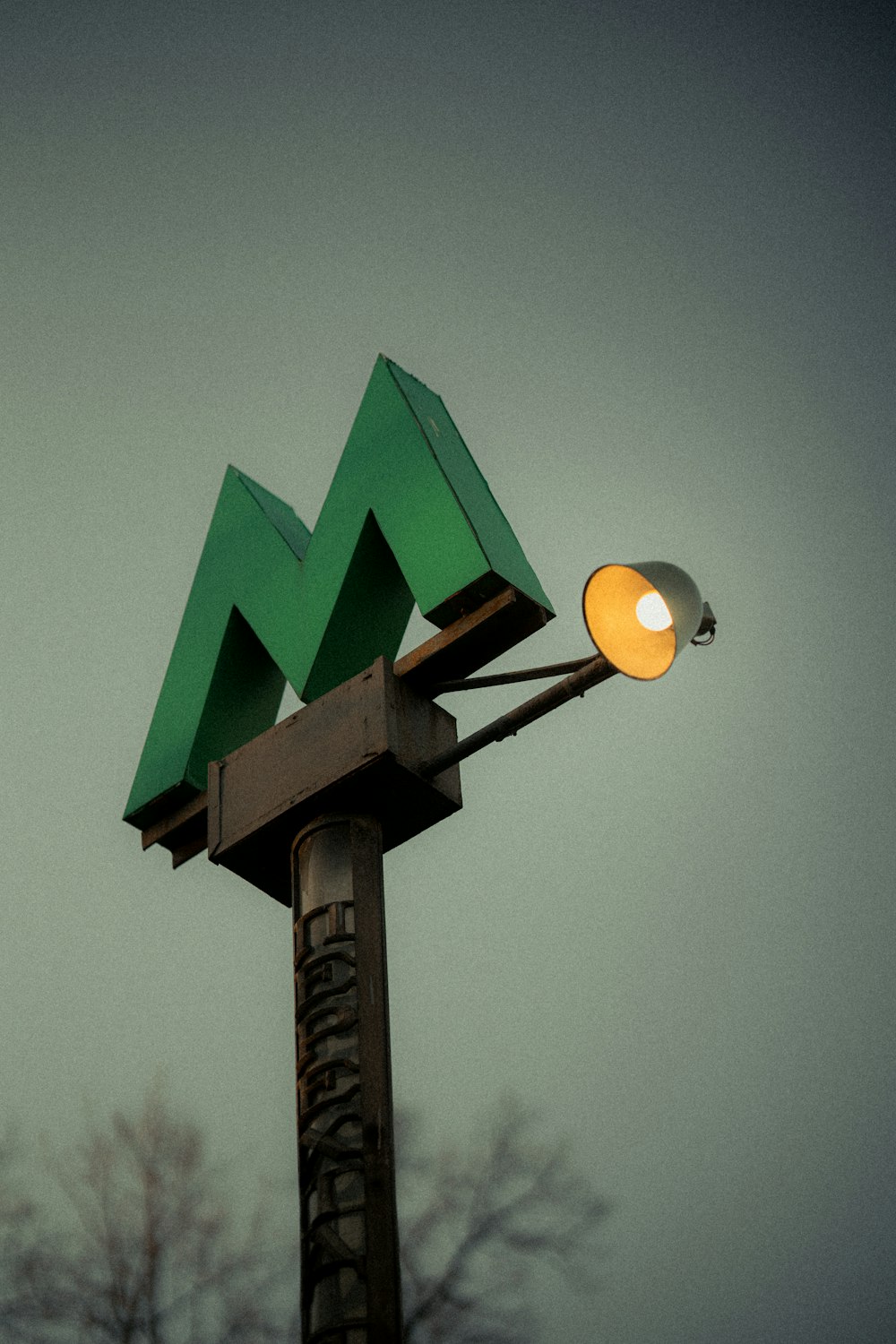 a street light with a green mountain on top of it