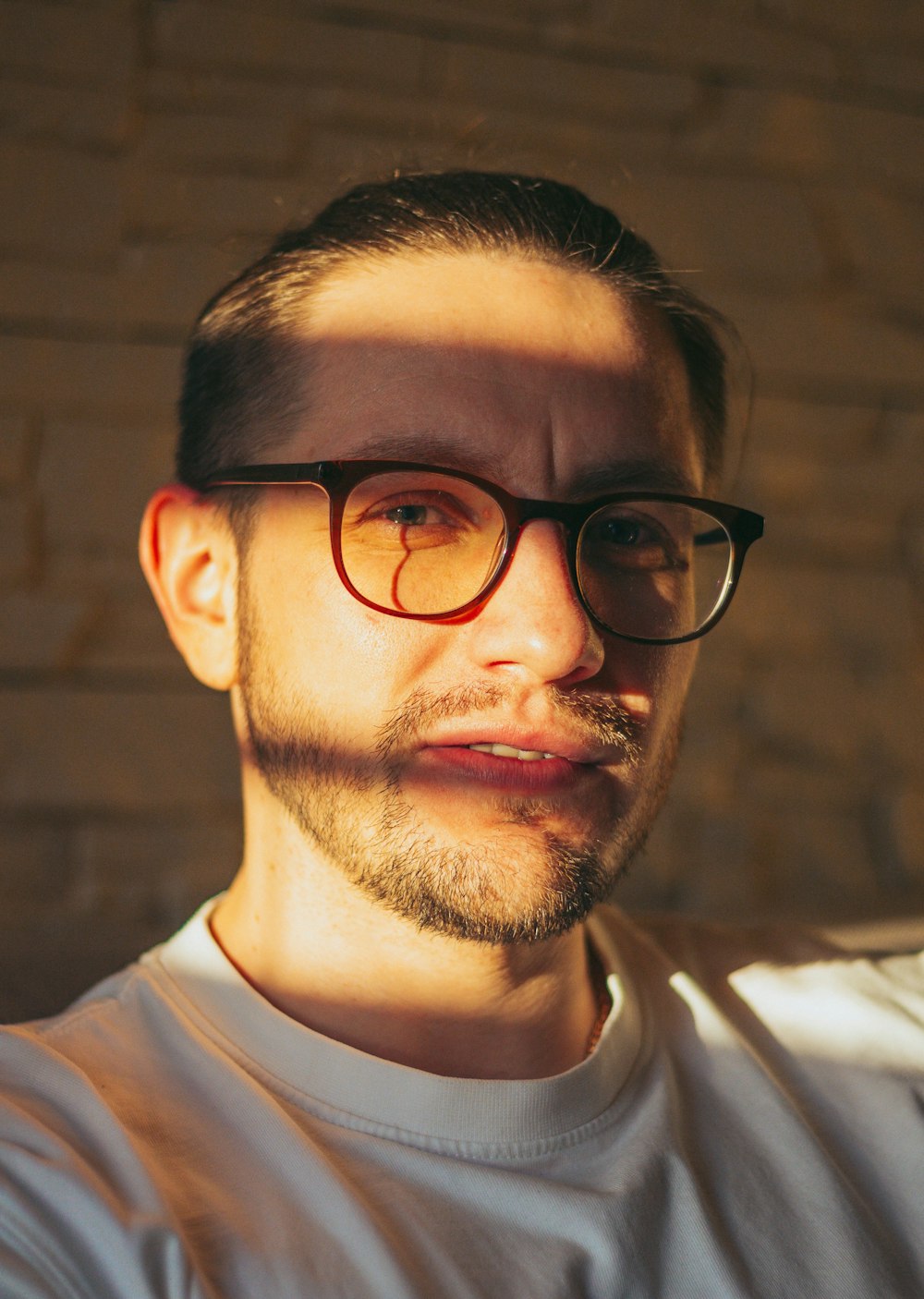 a man with a beard and glasses looking at the camera