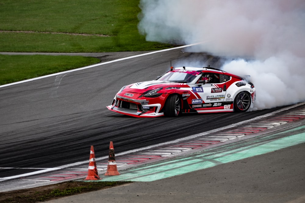 a car with smoke coming out of it driving on a track