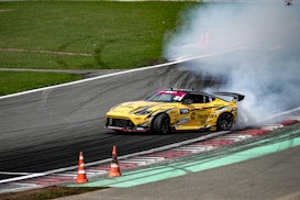 a yellow race car with smoke coming out of it