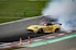 a yellow race car with smoke coming out of it