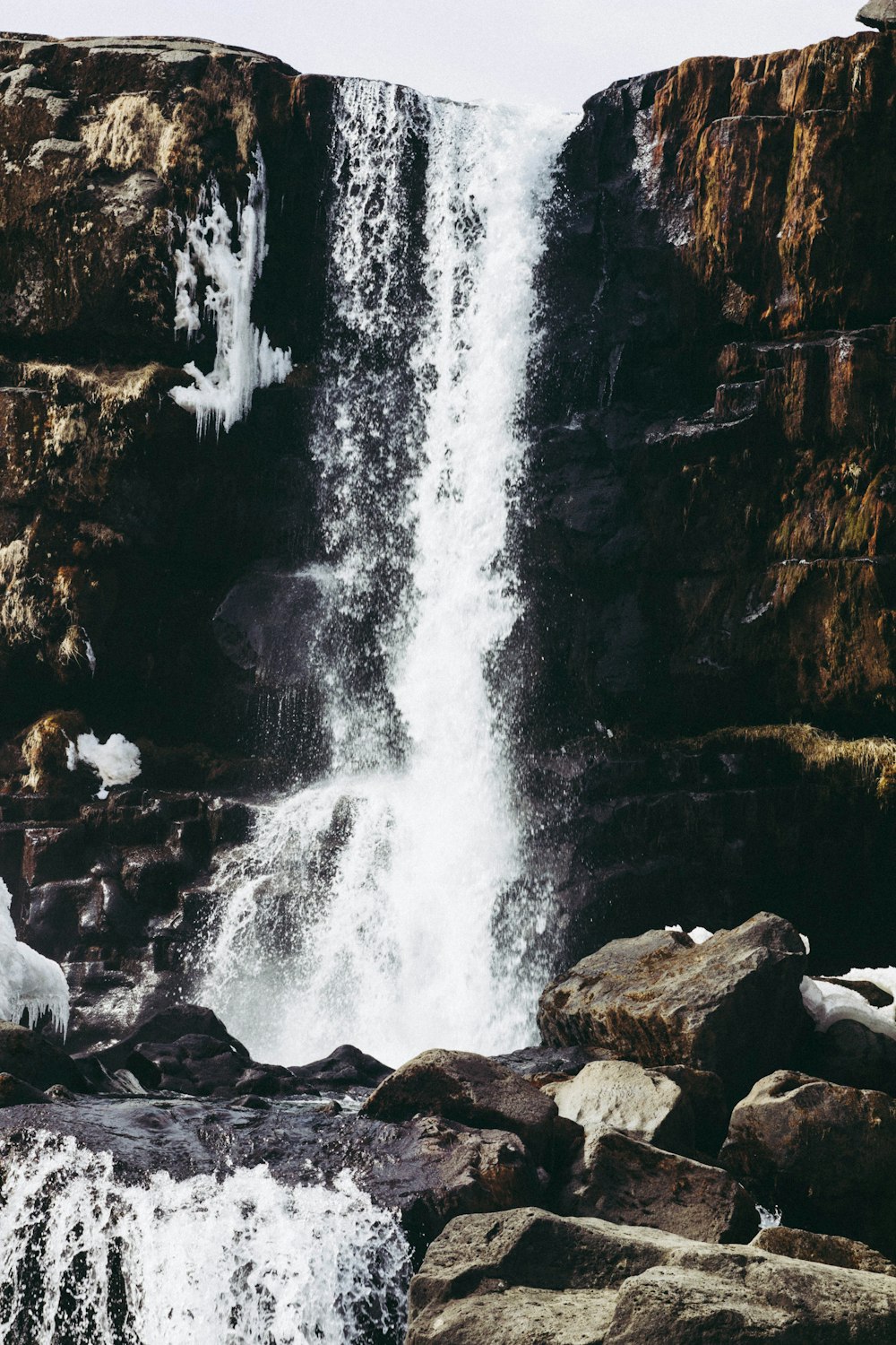 a man standing in front of a waterfall