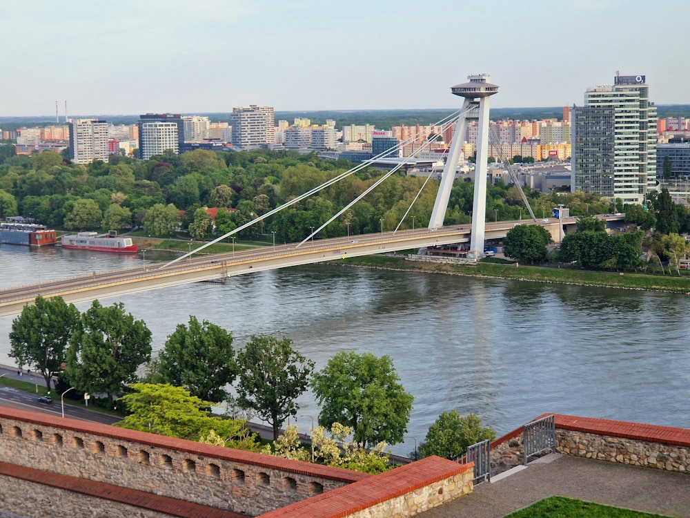 a bridge over a river with a city in the background