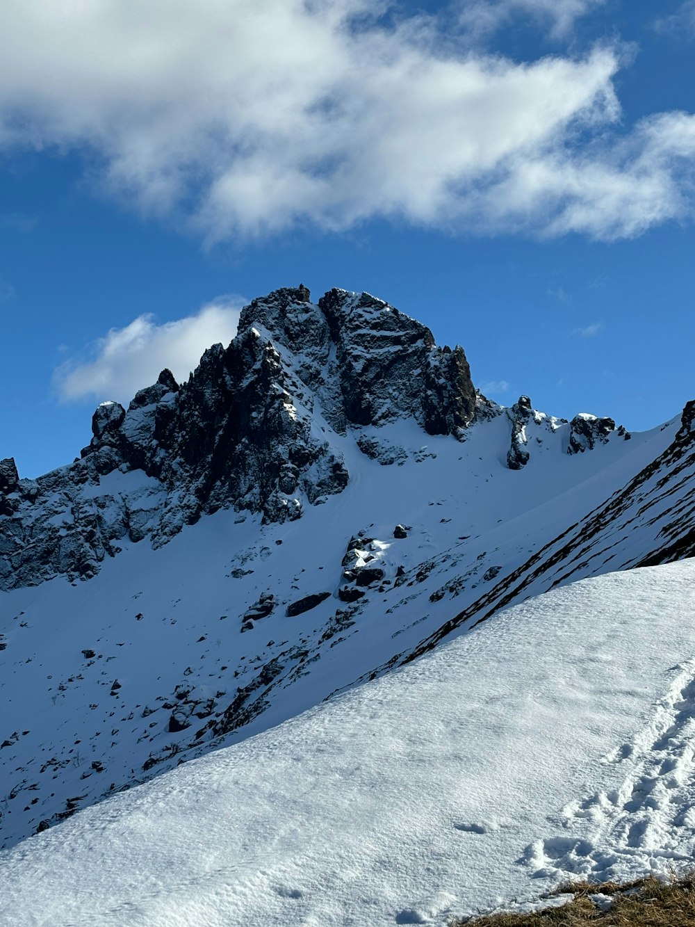 a snow covered mountain with tracks in the snow