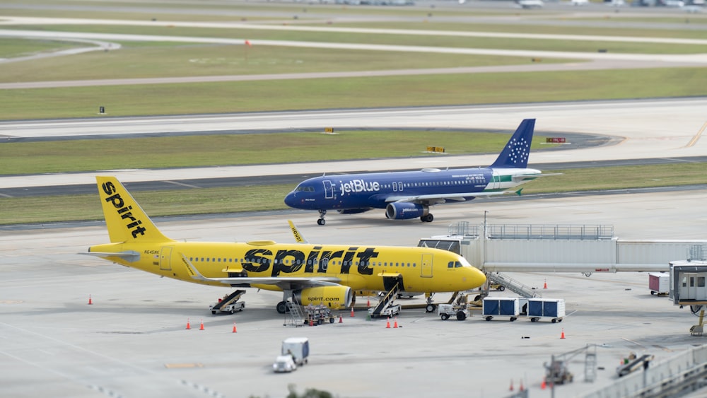 a yellow and blue jet airliner sitting on top of an airport tarmac