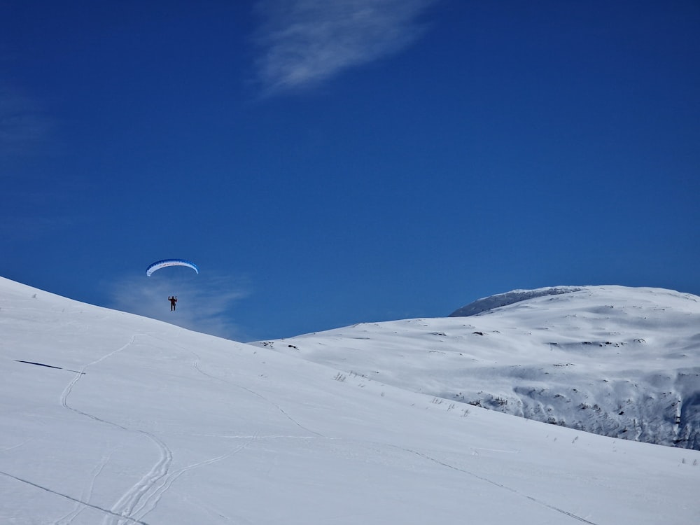 a person riding a snowboard down a snow covered slope