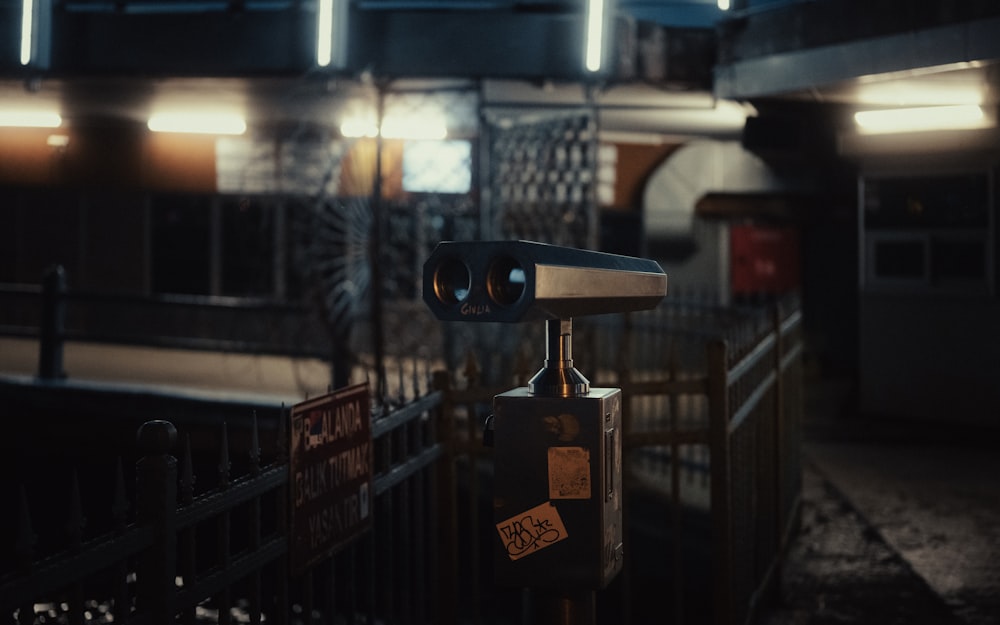 a pair of binoculars sitting on top of a metal fence