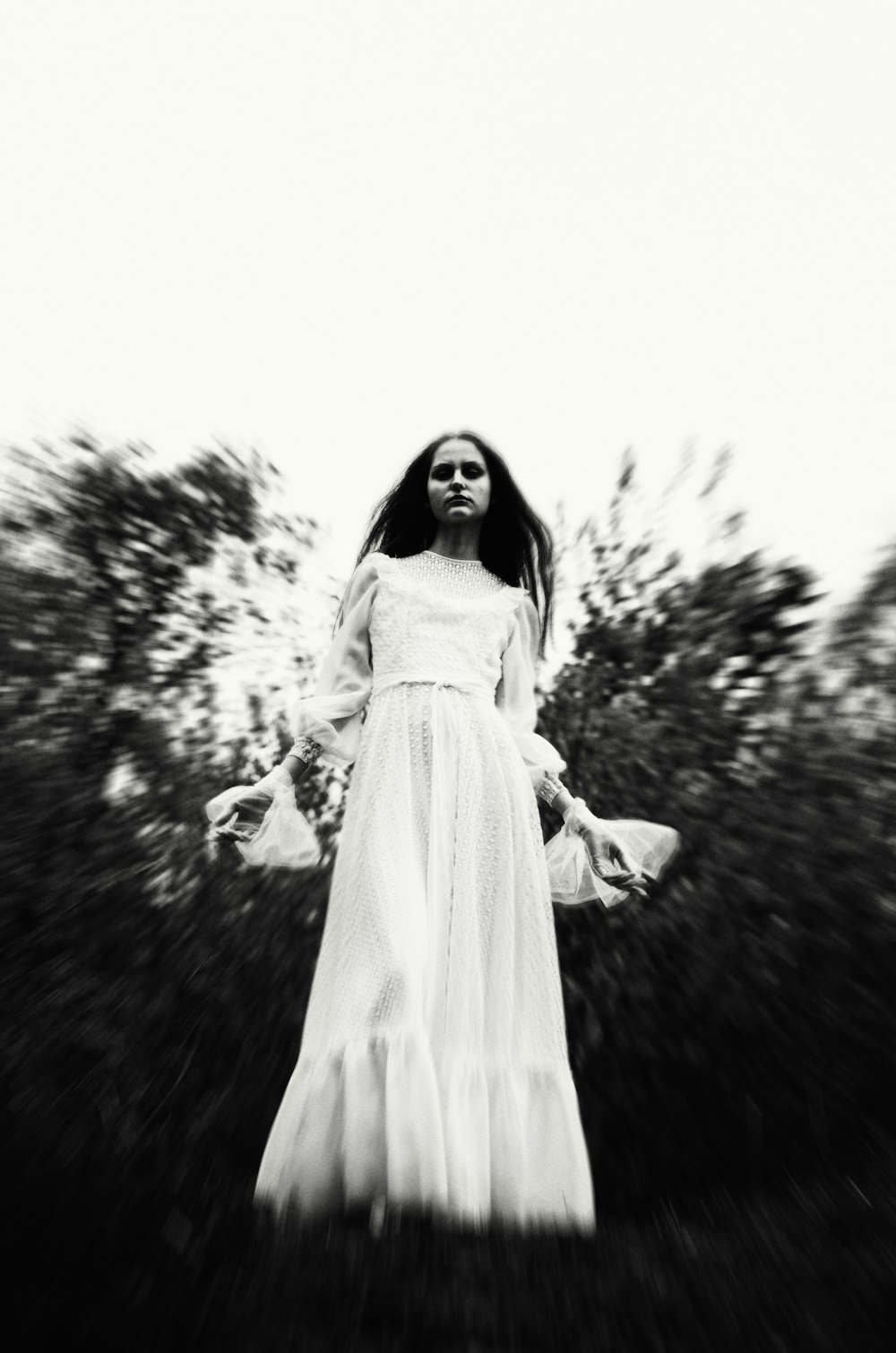 a woman in a white dress standing in a field