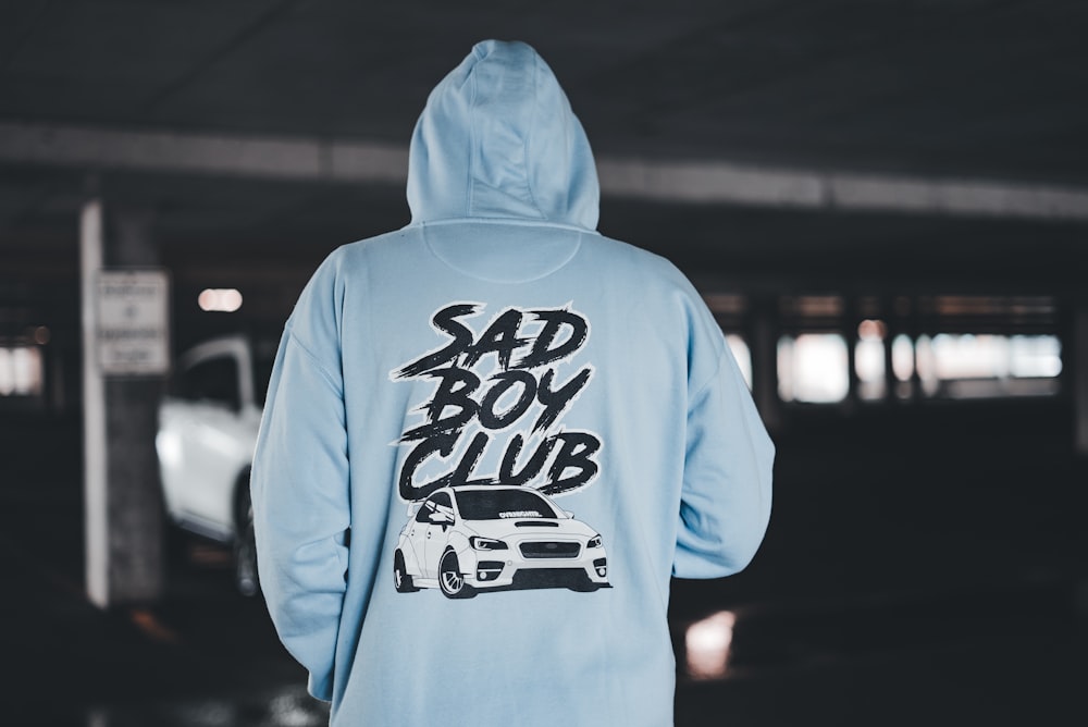 a person wearing a blue hoodie with a car on it