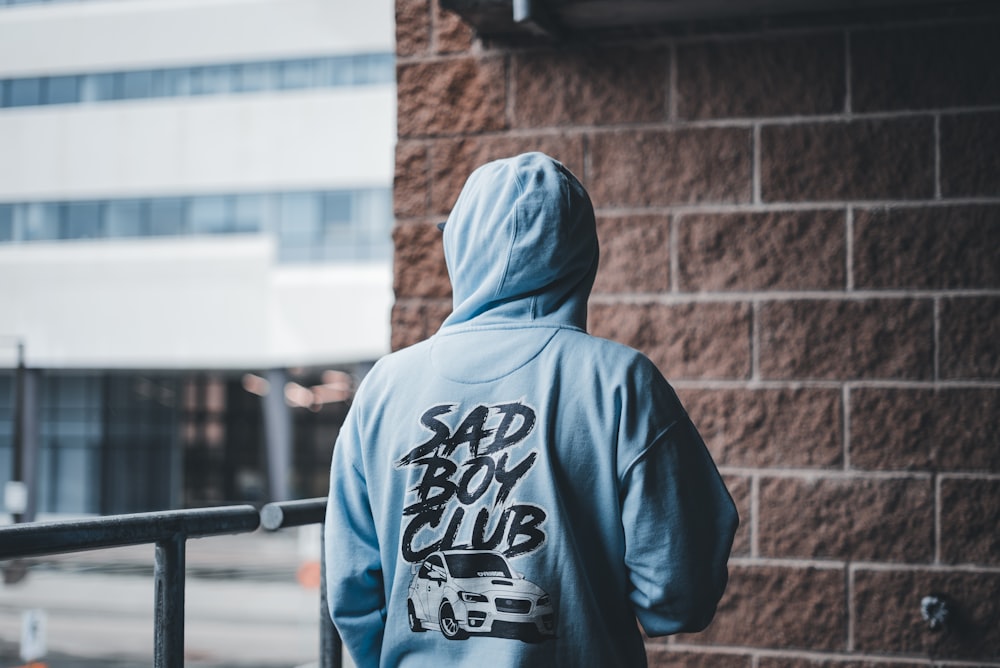 a man in a blue hoodie walking down a street