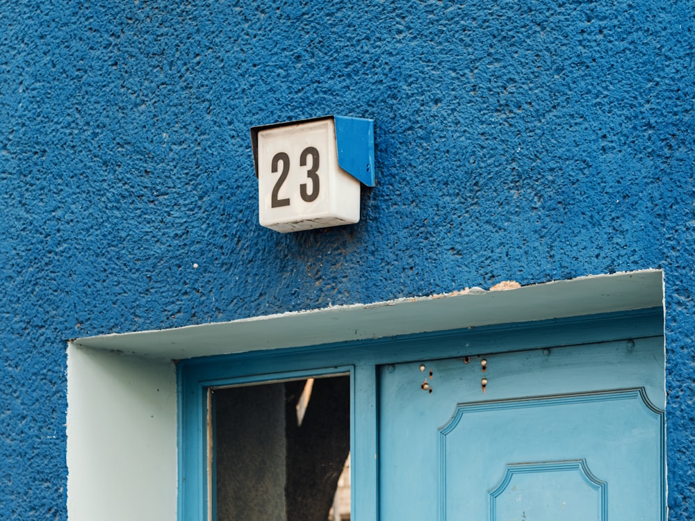 a blue door with a number sign on it