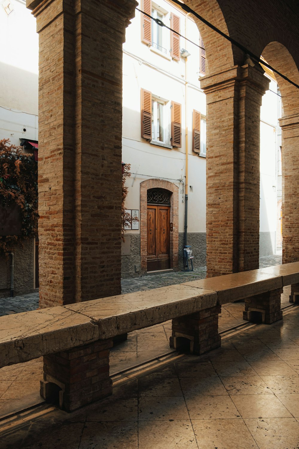 a long stone bench sitting under an archway