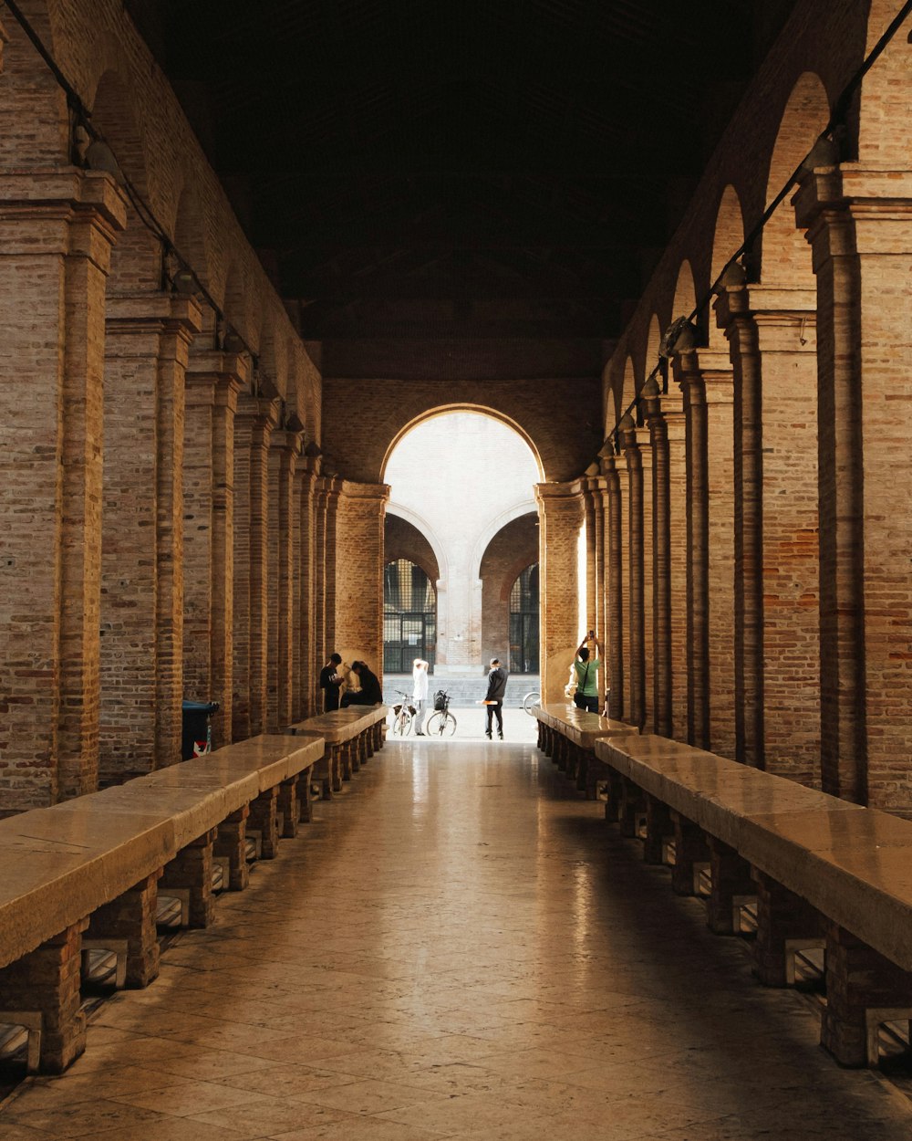 a couple of people walking down a long hallway