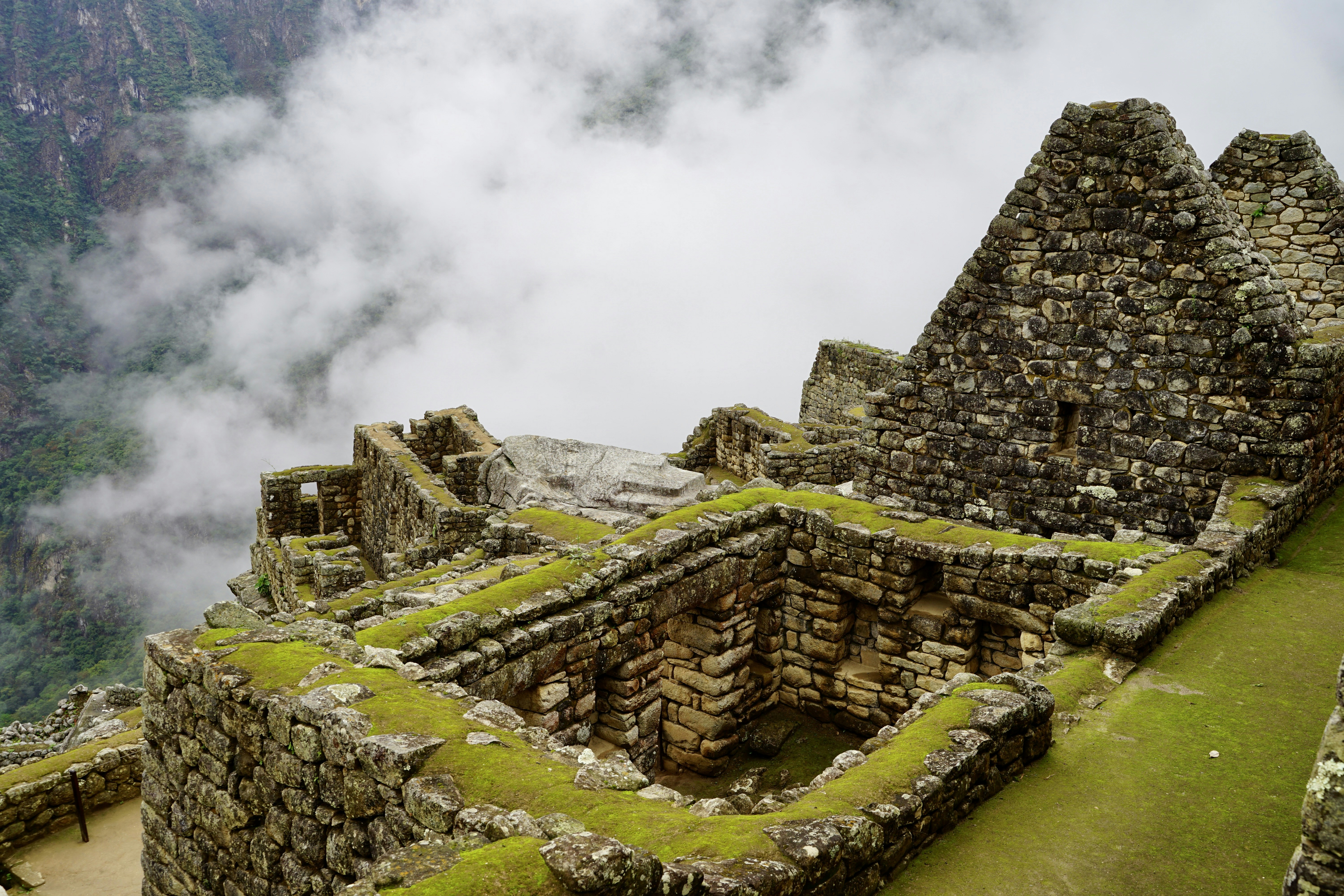 a stone structure with moss growing on top of it, 