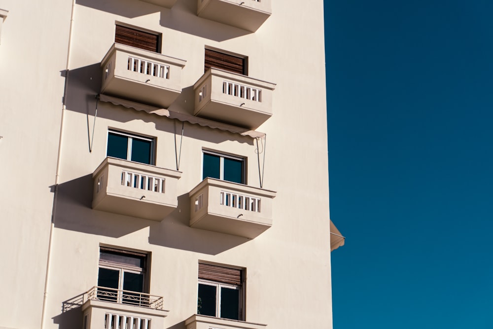 a tall white building with balconies and balconies