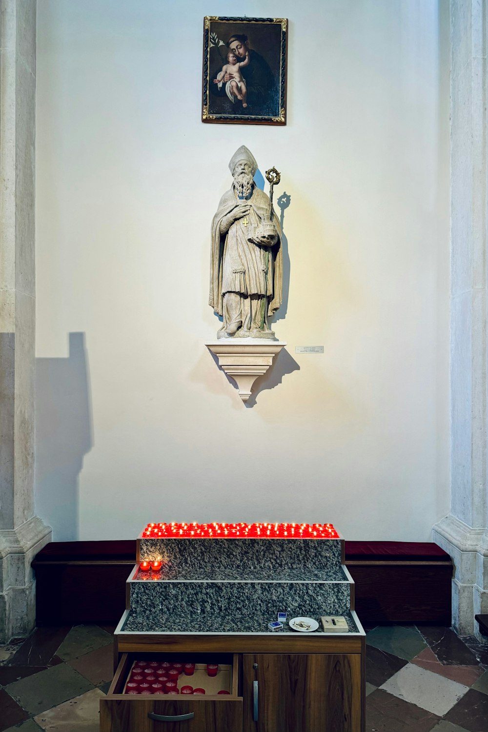 a statue of a person with a candle in front of it