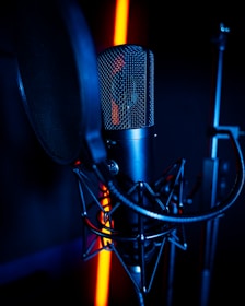 a microphone and a microphone stand in a dark room
