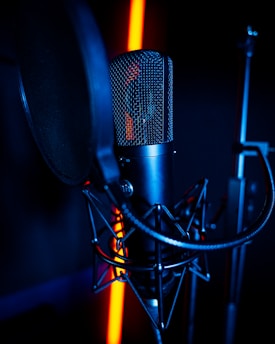 a microphone and a microphone stand in a dark room