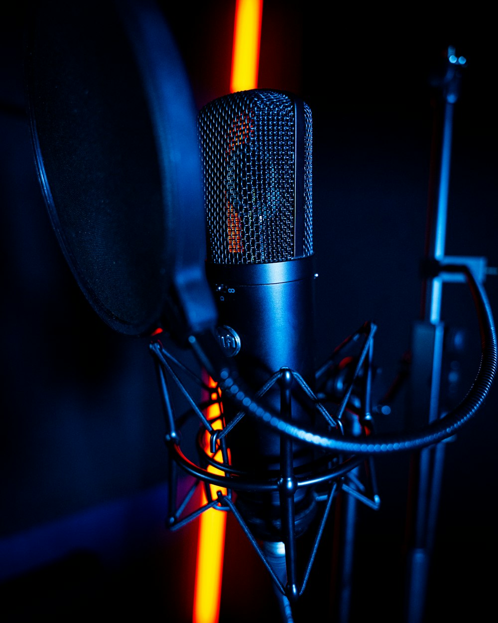 a microphone and a microphone stand in a dark room