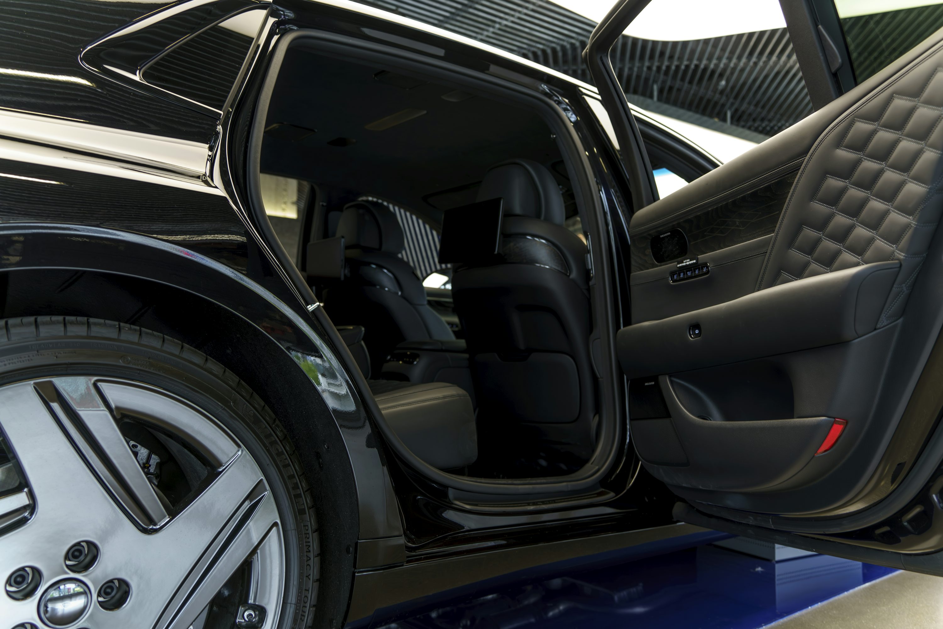 a car with its door open on a showroom floor