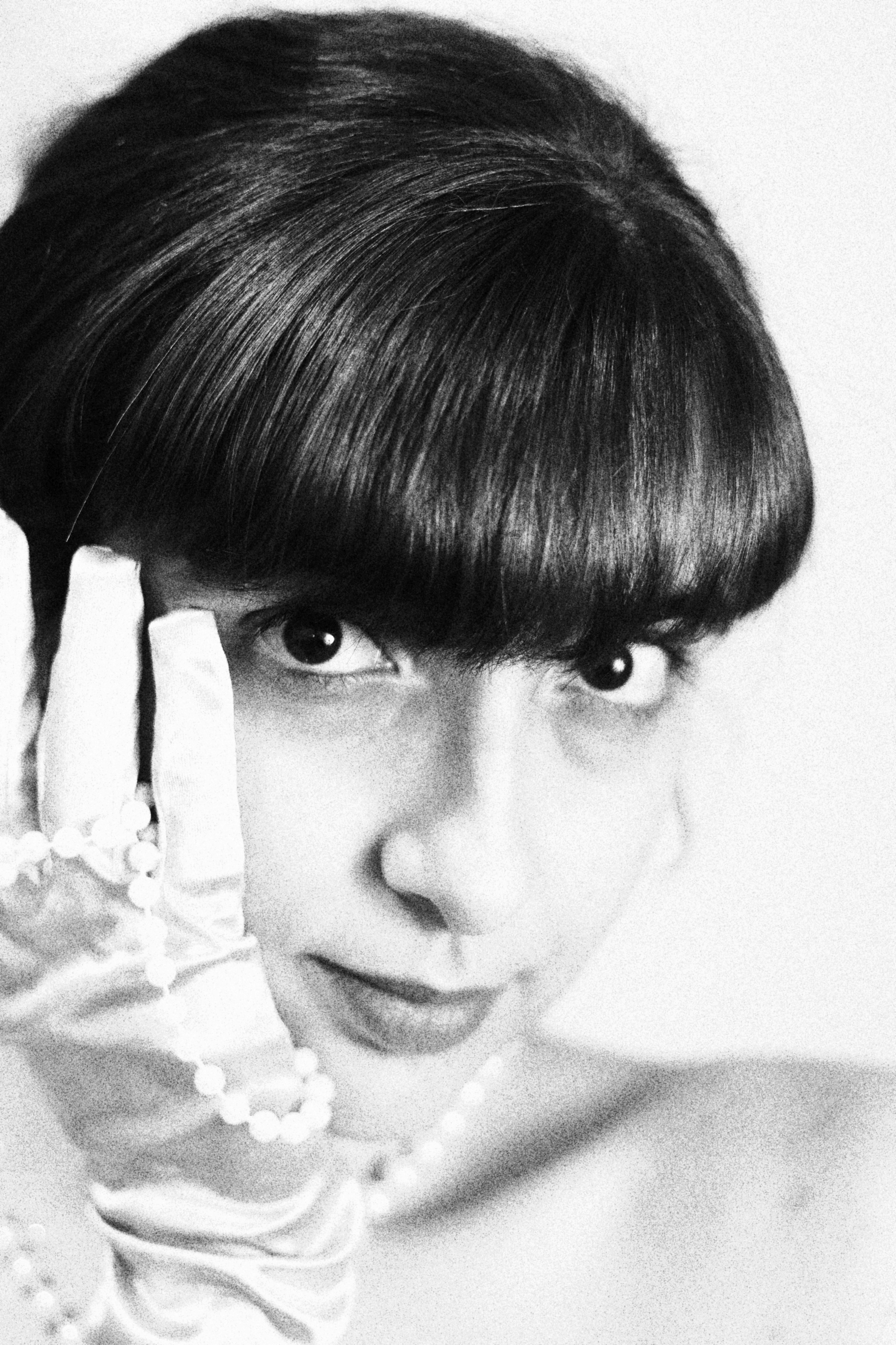 a black and white photo of a woman wearing gloves