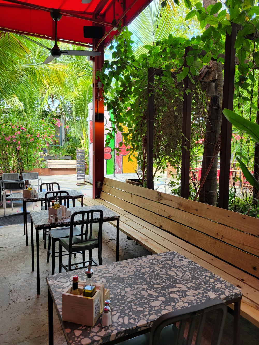 a restaurant with tables and chairs under a canopy