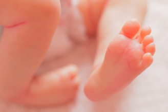 a close up of a person's feet with a tiny orange object in the