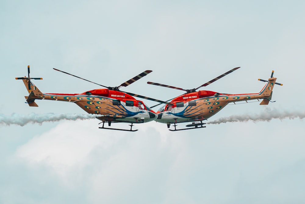 two red and white helicopter flying next to each other