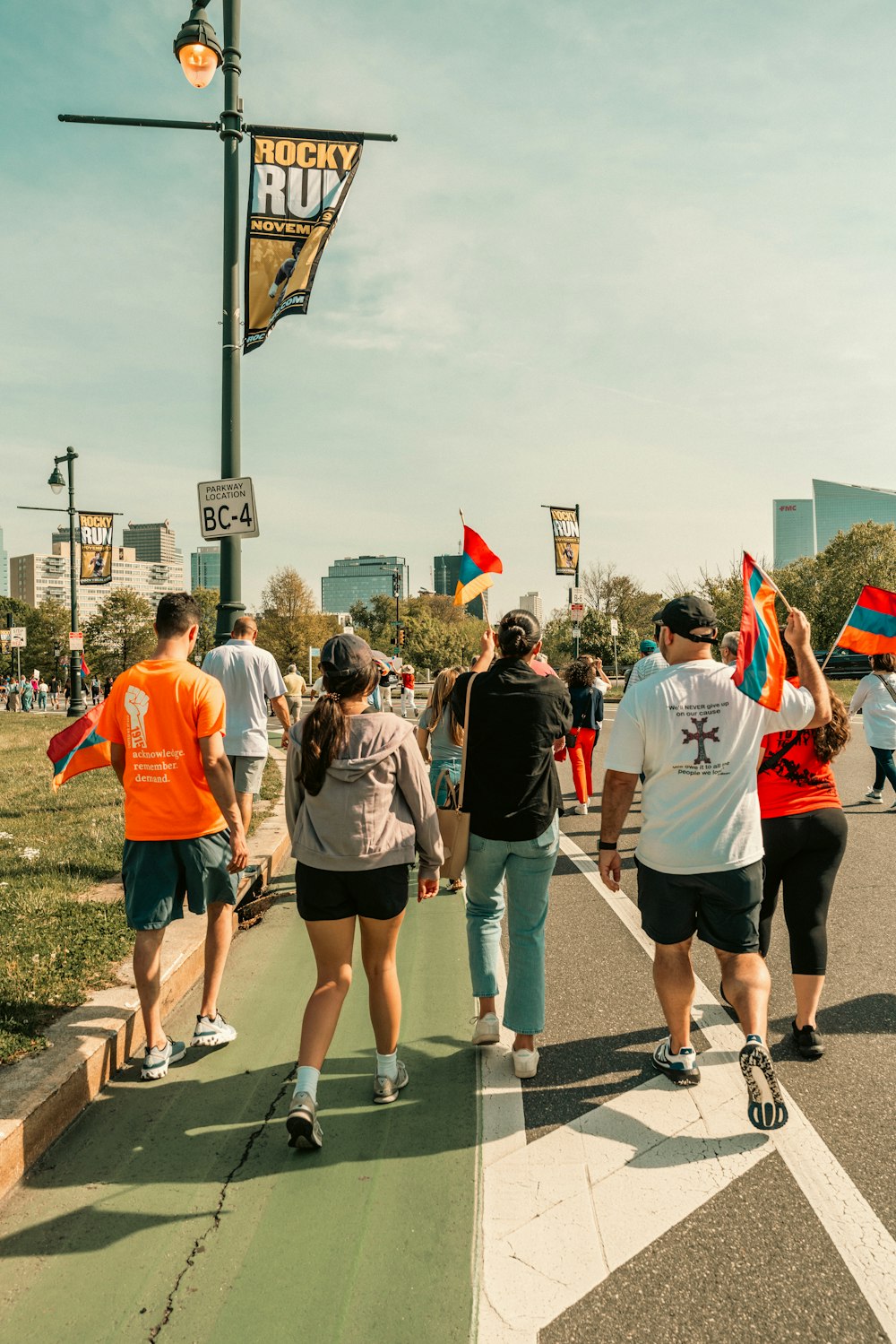 a group of people walking down a street holding flags