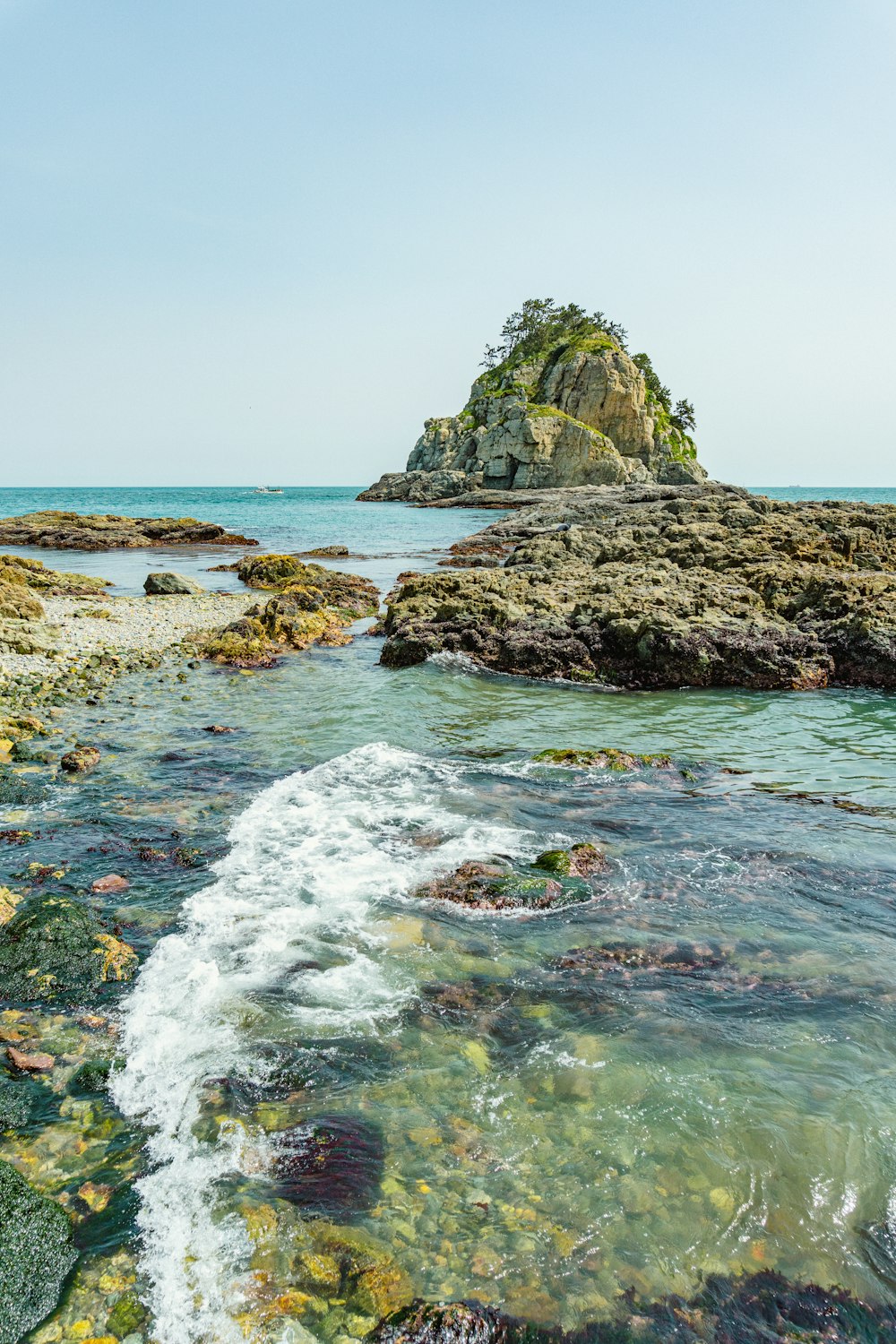 a body of water with rocks in the background